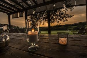 una vela en un jarrón de cristal sobre una mesa de madera en Villa degli Amanti - Homelike Villas, en Terranuova Bracciolini