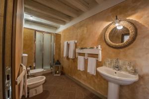 Un baño con lavabo, inodoro y espejo. en Villa degli Amanti - Homelike Villas, en Terranuova Bracciolini 13 fotos más