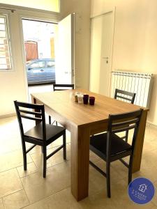 mesa de madera con 2 sillas y comedor en I CASERE D V'NGINZ - HOLIDAYS APARTMENTS, en Mola di Bari