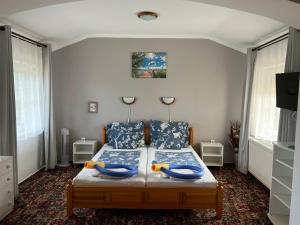 een slaapkamer met een bed met twee blauwe kussens bij Magic Garten in Hévíz