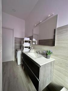 La salle de bains est pourvue d'un lavabo et d'un grand miroir. dans l'établissement Simply House Civitavecchia, à Civitavecchia