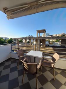 una mesa y sillas en un balcón con vistas en Arjana & Nelaj Apartments, en Ksamil