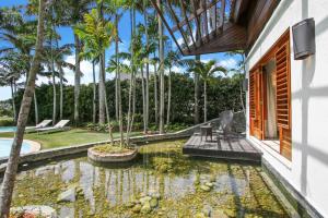 a house with a koi pond in a yard at Luxurious 8-BR Villa with Ocean View, Jacuzzi, Home Cinema and Resort Access in Casa de Campo in La Romana