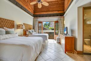 1 dormitorio con 2 camas y TV. en Luxurious 8-BR Villa with Ocean View, Jacuzzi, Home Cinema and Resort Access in Casa de Campo, en La Romana