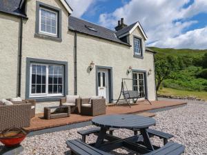 a patio with a table and chairs in front of a house at Croft House in Mallaig