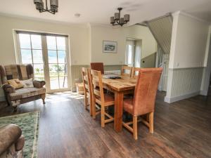 a dining room with a wooden table and chairs at Croft House in Mallaig