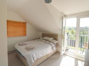 a bedroom with a bed and a large window at 5 Forest Park Lodge in High Bickington