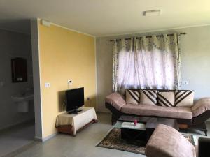 sala de estar con sofá y TV en Villa Karim, en Nabeul