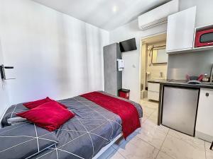 ein Schlafzimmer mit einem Bett mit einem roten Kissen darauf in der Unterkunft Sweet Home Marceau 6 studios hyper centre proche de la mer et du palais in Cannes