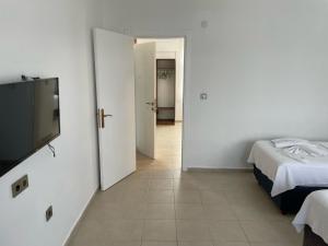 a room with two beds and a flat screen tv at Parli Hotel in Gokceada Town