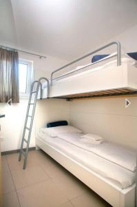 Daška Apartmani في نجيفيش: سريرين بطابقين في غرفة مع سلم