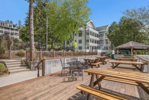 a group of picnic tables and chairs on a wooden deck at Lakeside Suites in Elkhart Lake