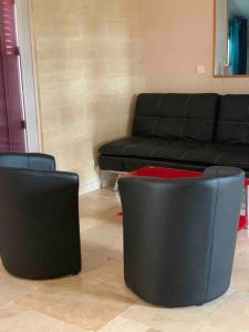 2 sillas negras en la sala de estar con sofá en Villa feng shui, en Fargues-de-Langon
