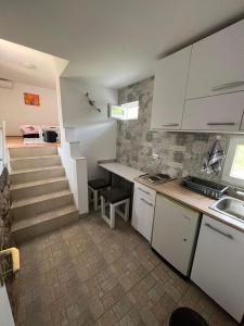 a kitchen with white cabinets and stairs in a room at Studio Biki in Banja Koviljača +5 photos