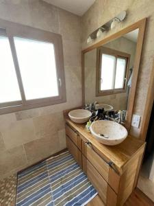 un bagno con due lavandini e un grande specchio di Villa feng shui a Fargues-de-Langon