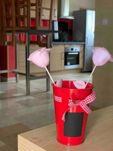 a red cup with two pink flowers on a table at Villa feng shui in Fargues-de-Langon