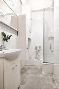 y baño blanco con lavabo y ducha. en Beautiful rooms in the center, en Szczecin