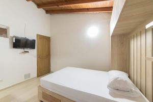 1 dormitorio con 1 cama y TV en la pared en Medellín Minimal apartment Pet Friendly 203, en Medellín