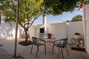 un patio con mesa, sillas y un árbol en Cantinho da Ana, en Tomar