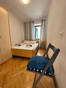 1 dormitorio con silla, cama y ventana en Apartment SEAGULL, en Igrane