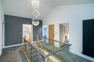 a staircase in a house with a glass railing at Brand New Barn Retreat in Bedford