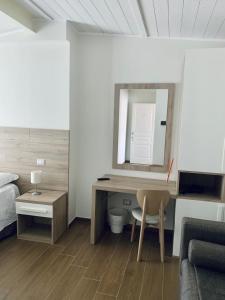 una camera da letto con scrivania, letto e specchio di Tempio Aurora a San Costantino Albanese