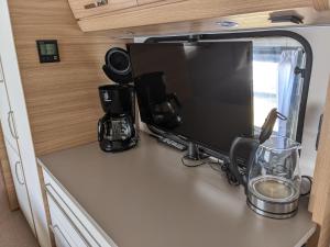 a tv on a counter in an rv at Luxuswohnwagen Forelle am Kransburger See 004 in Kransburg