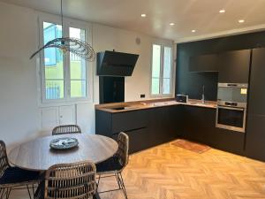 een keuken met een tafel en stoelen en een keuken met een aanrecht bij Maison de Ville Cannes Centre in Cannes