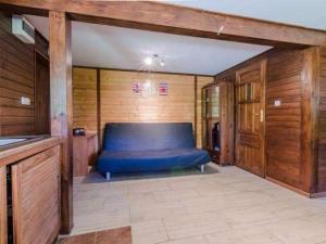 米科瓦伊基的住宿－Idea Domki，一张蓝色的大床,位于带木墙的房间