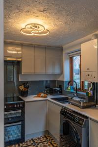 a kitchen with a sink and a dishwasher at 2 Bedroom Rural Escape In Peaceful Elmswell in Woolpit