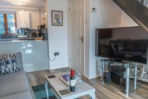 a living room with a couch and a tv and a table at 2 Bedroom Rural Escape In Peaceful Elmswell in Woolpit