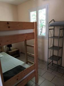 een slaapkamer met een stapelbed en een raam bij CAMPING HERMITAGE DES 4 SAISONS in Saint-Julien-de-Bourdeilles