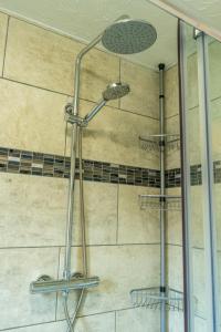 een douche met een douchekop in de badkamer bij 2 Bedroom Rural Escape In Peaceful Elmswell in Woolpit