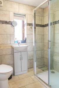 een badkamer met een douche, een wastafel en een toilet bij 2 Bedroom Rural Escape In Peaceful Elmswell in Woolpit