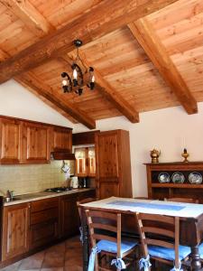 una cucina con soffitti in legno e tavolo con sedie di Casa Vacanze Elisa a Sauze d'Oulx
