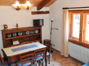 uma sala de jantar com uma mesa e uma janela em Casa Vacanze Elisa em Sauze dʼOulx
