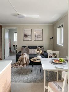 un soggiorno con divano e tavolo di Beautiful apartment near forest, sea and city a Sandefjord