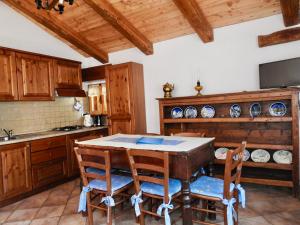 uma cozinha com uma mesa de madeira e cadeiras em Casa Vacanze Elisa em Sauze dʼOulx