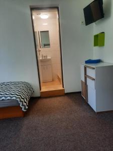 Habitación con cama y baño con espejo. en Penzion a restaurace Windows en Mařenice