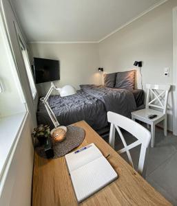 a small room with a bed and a table with a desk sidx sidx sidx at Beautiful apartment near forest, sea and city in Sandefjord