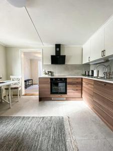 a large kitchen with wooden cabinets and a table at Beautiful apartment near forest, sea and city in Sandefjord