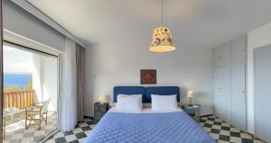 um quarto com uma cama azul e uma varanda em Casa Bianca Elegant House Near Beach em Spetses