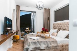 ein Hotelzimmer mit einem Bett und einem TV in der Unterkunft CAROLEA VILLAS in Ulcinj
