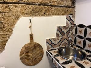 Łazienka z drewnianą toaletą i umywalką w obiekcie FraLePorte Vintage Apartment w mieście Palermo