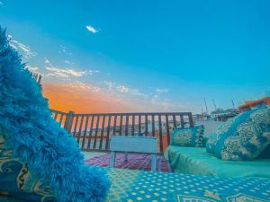 - un canapé installé sur un balcon avec vue sur le coucher du soleil dans l'établissement Taghazout Surf House, à Taghazout