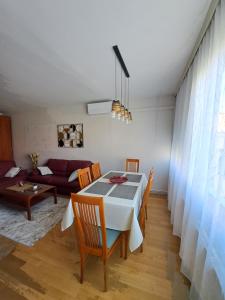 a dining room with a table and chairs and a couch at Apartman Iadera in Zadar +11 photos