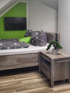 ein Schlafzimmer mit einem großen Bett und einer grünen Wand in der Unterkunft Zum Pieck Schwarzenberg in Schwarzenberg/Erzgebirge