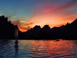 een vrouw die in het water staat bij zonsondergang bij XMAN Valley Sunrise Resort in Zhangjiajie