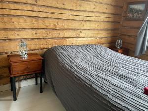 1 dormitorio con 1 cama y pared de madera en Stationmaster's studio, en Porvoo