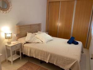 卡沃內拉斯的住宿－Ático 8 carboneras，一间卧室配有一张带蓝色枕头的床